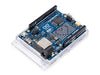 Angled perspective of the Arduino UNO R4 WiFi board, showcasing component layout including the microcontroller, ESP32-S3 module, and LED matrix.